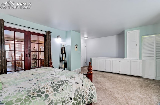 bedroom featuring french doors and light carpet