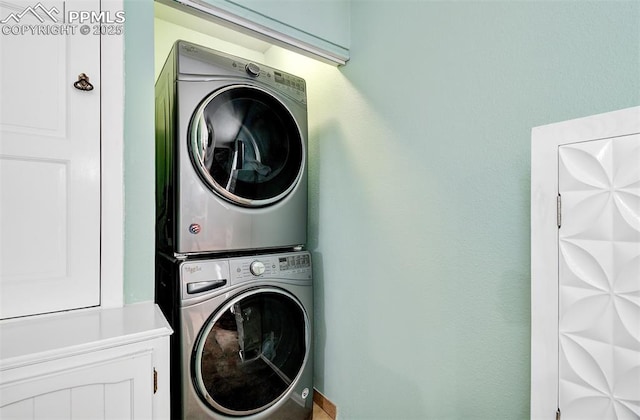 clothes washing area with stacked washer / dryer