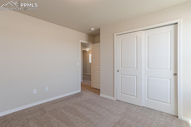 unfurnished bedroom featuring a closet and light carpet