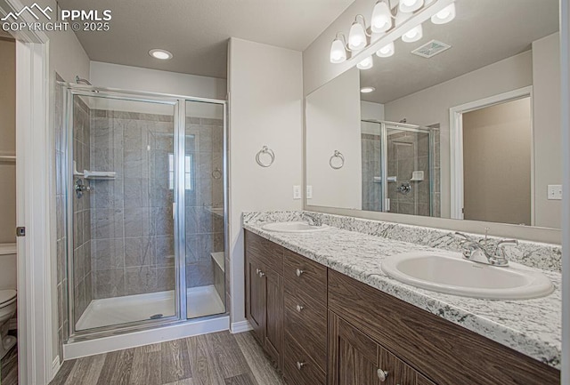 bathroom with vanity, toilet, and a shower with door