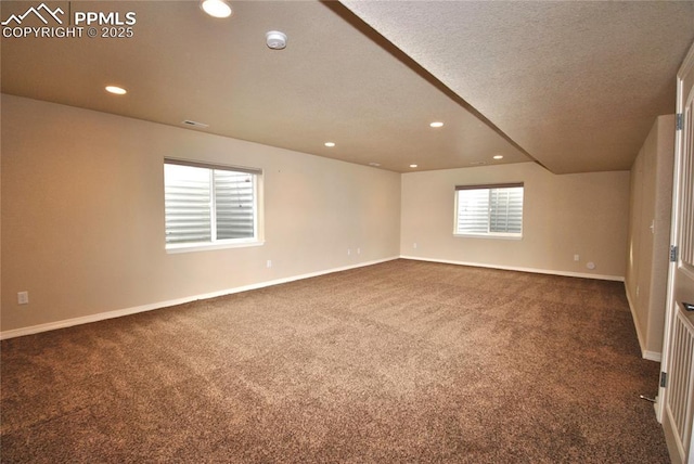 carpeted empty room with a textured ceiling