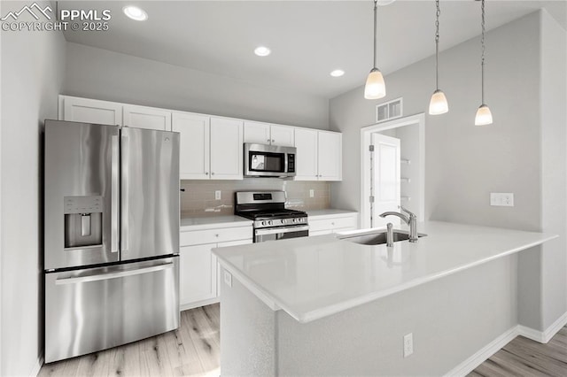 kitchen with sink, white cabinetry, pendant lighting, stainless steel appliances, and decorative backsplash