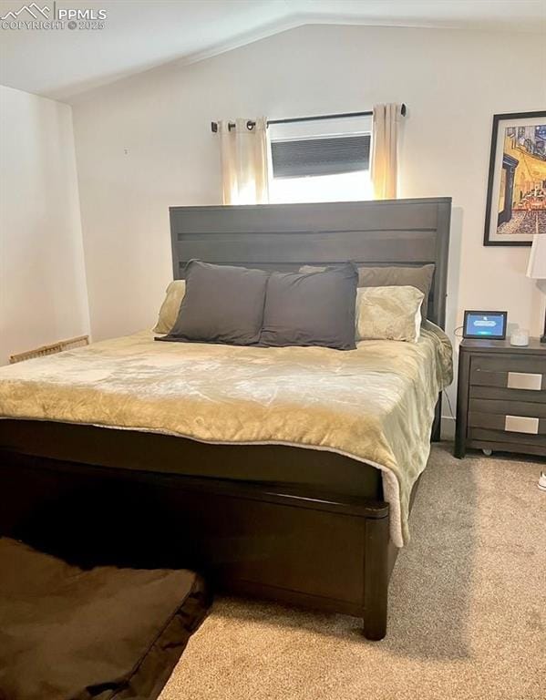 carpeted bedroom with lofted ceiling