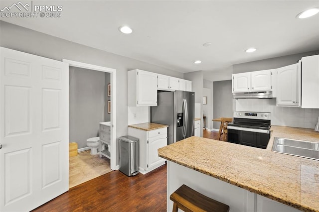 kitchen with dark wood-type flooring, appliances with stainless steel finishes, white cabinets, and sink