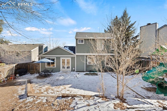 snow covered rear of property with french doors