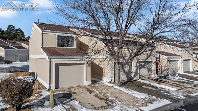 view of front of home with a garage and central AC