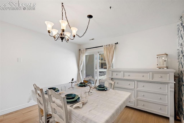 dining area featuring an inviting chandelier and light wood-type flooring