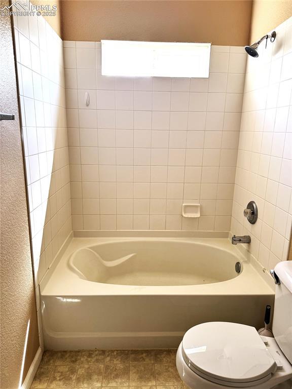 bathroom featuring shower / bath combination and toilet