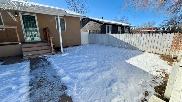 view of snow covered rear of property