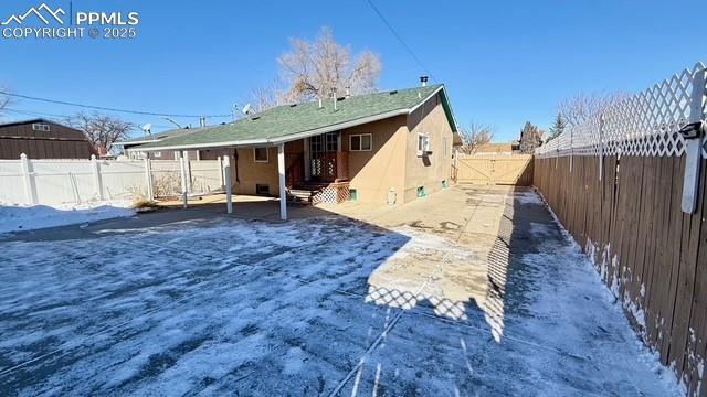 view of snow covered back of property