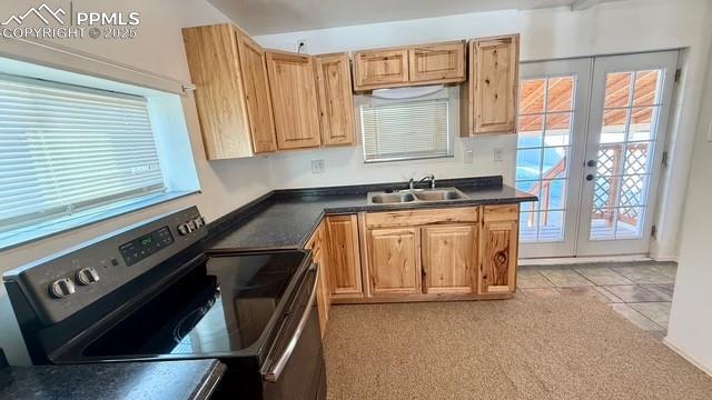 kitchen with sink, light tile patterned floors, stainless steel range with electric stovetop, and french doors