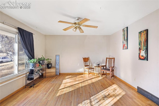 living area with hardwood / wood-style flooring and ceiling fan