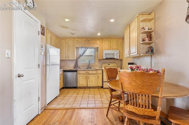 kitchen with sink, light brown cabinets, backsplash, and white appliances