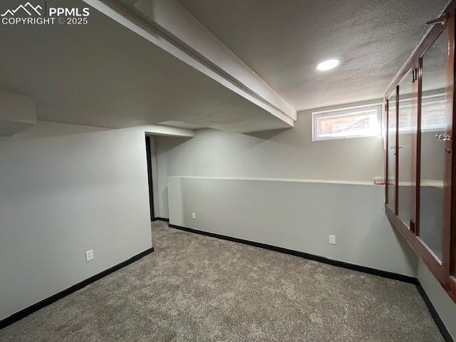 basement with light colored carpet and a textured ceiling