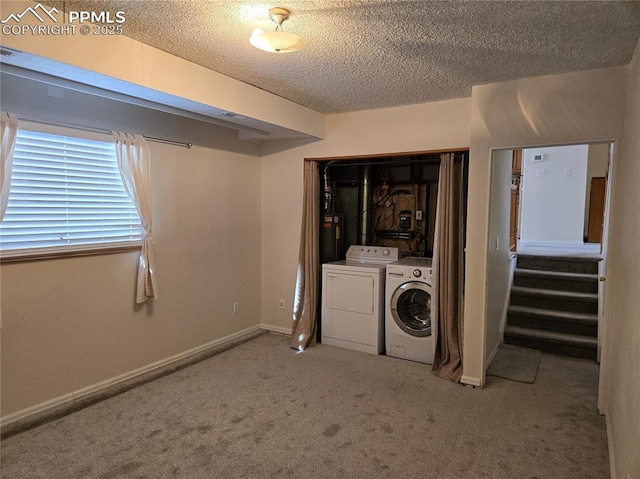 clothes washing area with a textured ceiling, carpet flooring, water heater, and washing machine and clothes dryer