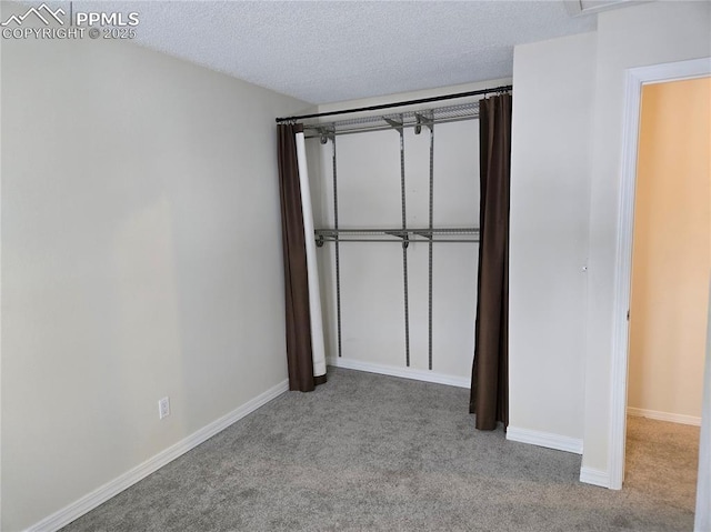 unfurnished bedroom with light colored carpet, a textured ceiling, and a closet