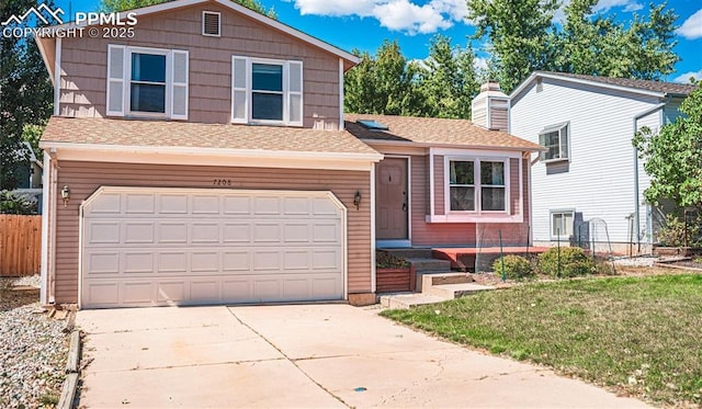 tri-level home with a garage and a front lawn