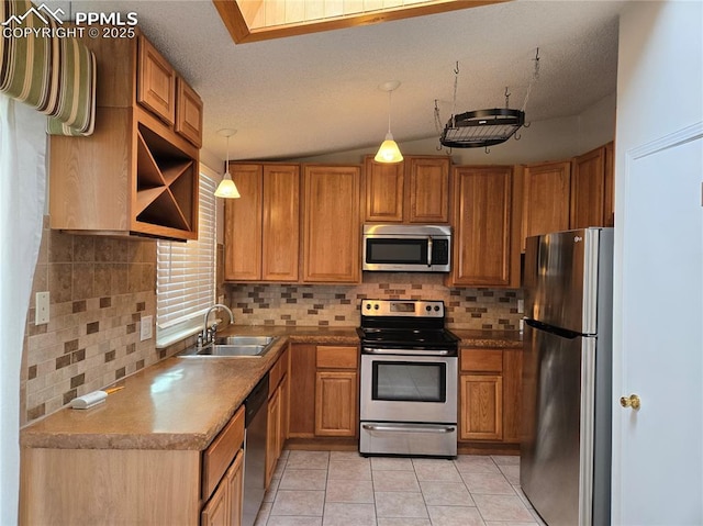 kitchen with decorative light fixtures, sink, tasteful backsplash, light tile patterned floors, and stainless steel appliances