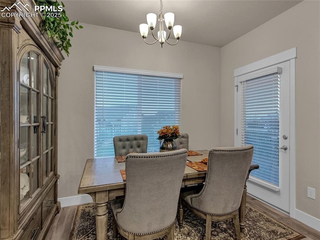 dining space featuring hardwood / wood-style flooring, plenty of natural light, and an inviting chandelier