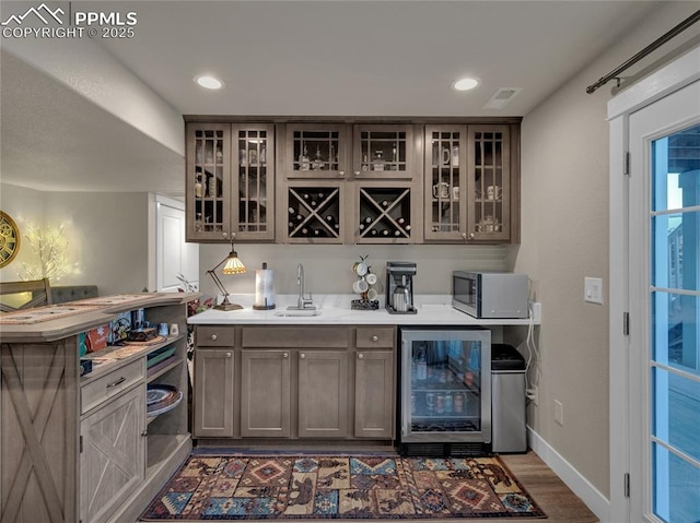 bar featuring sink, hardwood / wood-style flooring, and wine cooler