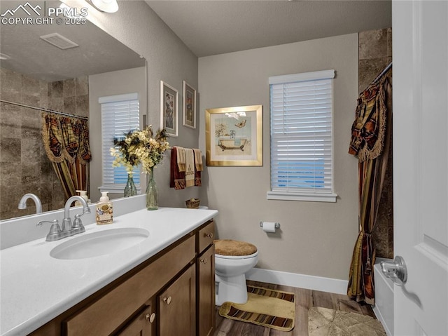 bathroom with wood-type flooring, curtained shower, toilet, and vanity