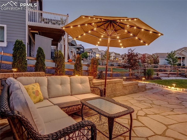 patio terrace at dusk with a balcony and an outdoor hangout area