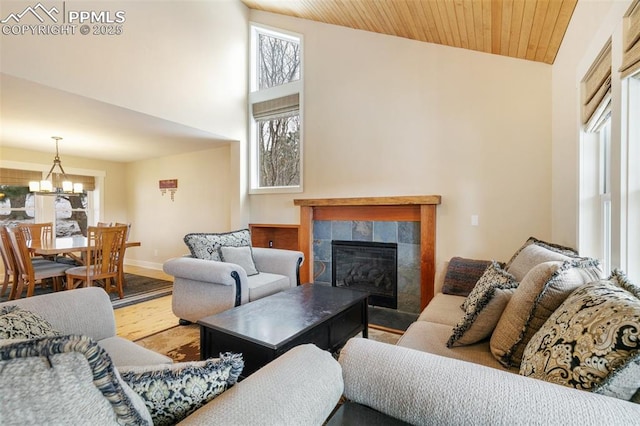 living room with wood ceiling, a fireplace, a chandelier, and hardwood / wood-style floors