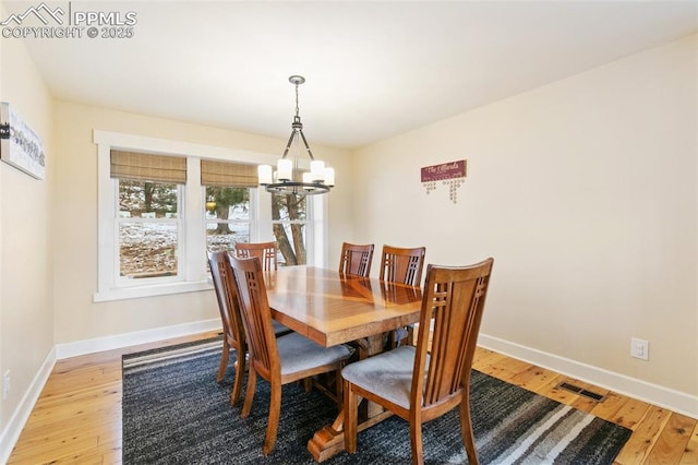 dining room with a chandelier and light wood-type flooring