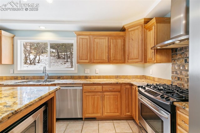 kitchen with light tile patterned flooring, range hood, sink, light stone counters, and stainless steel appliances