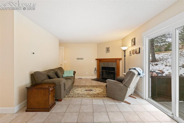 living room with light tile patterned floors, a tile fireplace, and a textured ceiling