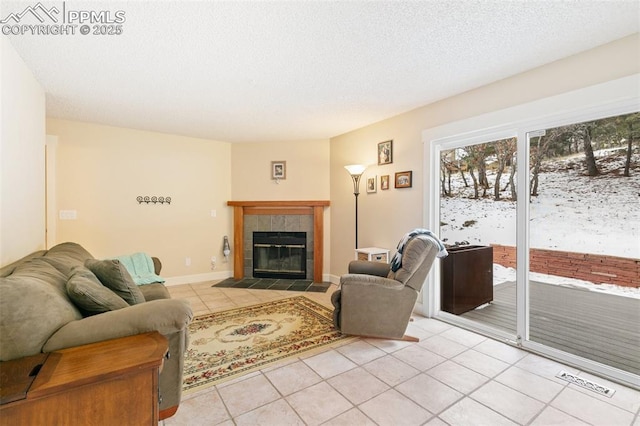 tiled living room featuring a textured ceiling and a fireplace