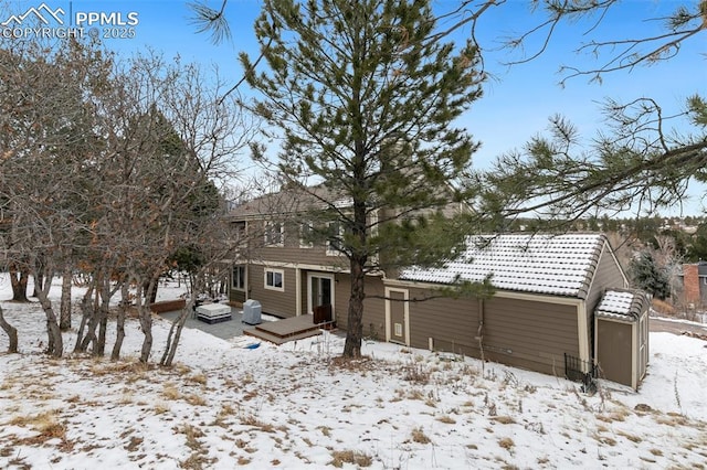 view of snow covered back of property