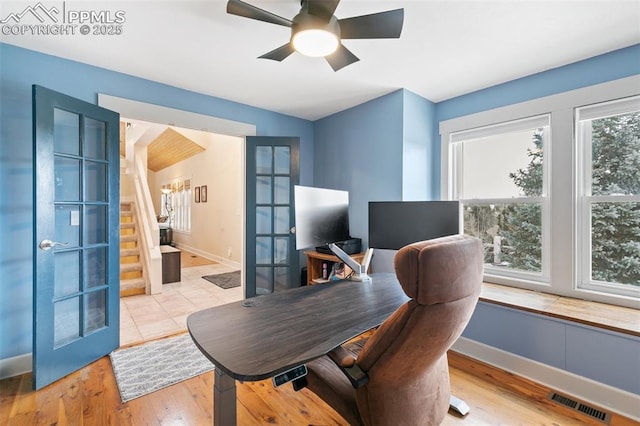 office area featuring a wealth of natural light, french doors, ceiling fan, and light wood-type flooring