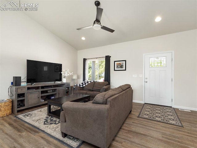 living room with ceiling fan, dark wood-type flooring, and lofted ceiling