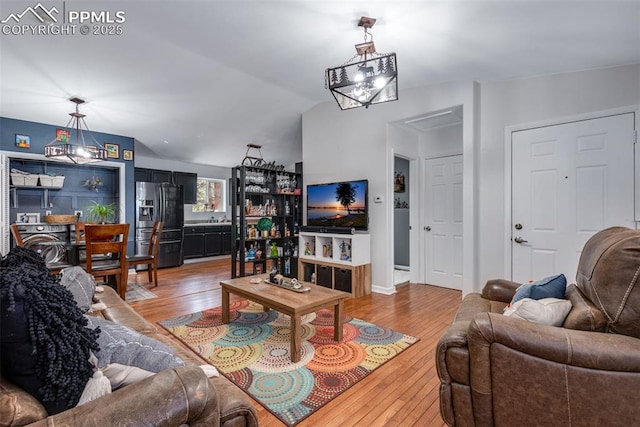 living room featuring sink, hardwood / wood-style floors, and vaulted ceiling