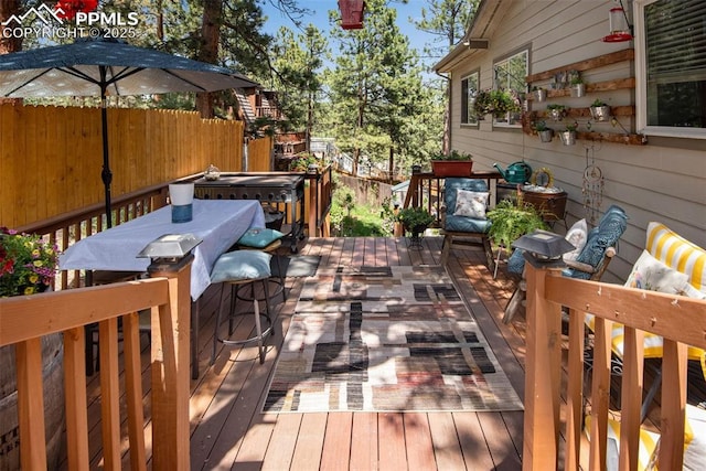 wooden terrace with a hot tub and a grill