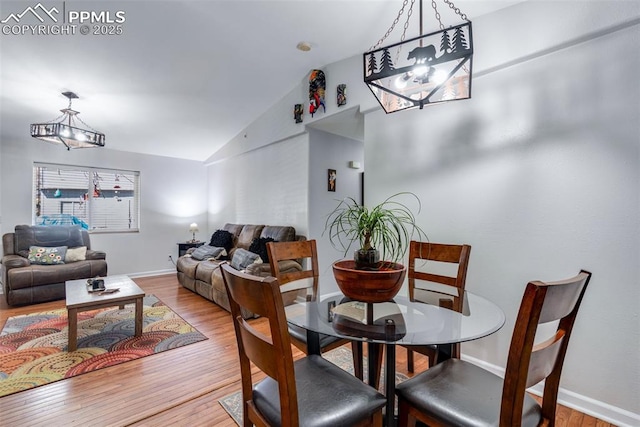 dining space with light hardwood / wood-style flooring and vaulted ceiling