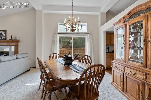 carpeted dining area featuring a notable chandelier and a fireplace