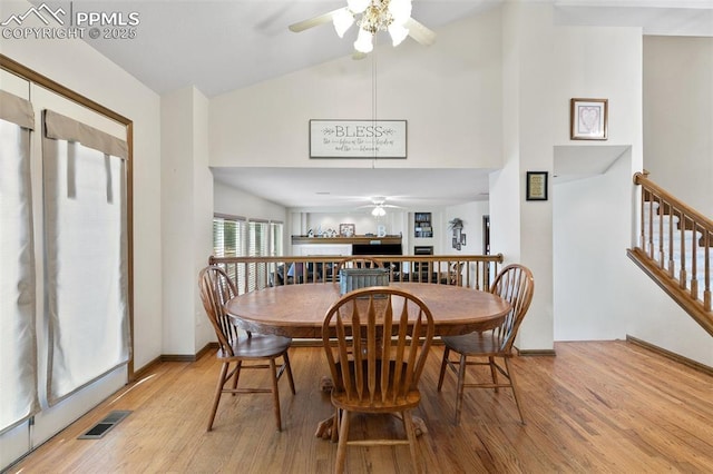 dining area with ceiling fan, light hardwood / wood-style flooring, and vaulted ceiling