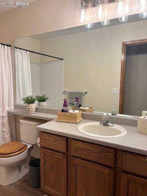 bathroom with vanity, toilet, and wood-type flooring