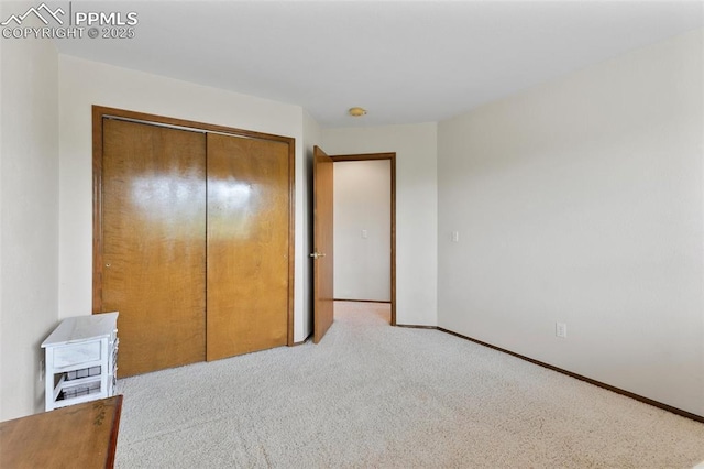 unfurnished bedroom with light carpet and a closet