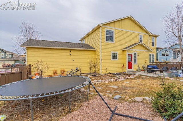 back of property with a patio and a trampoline