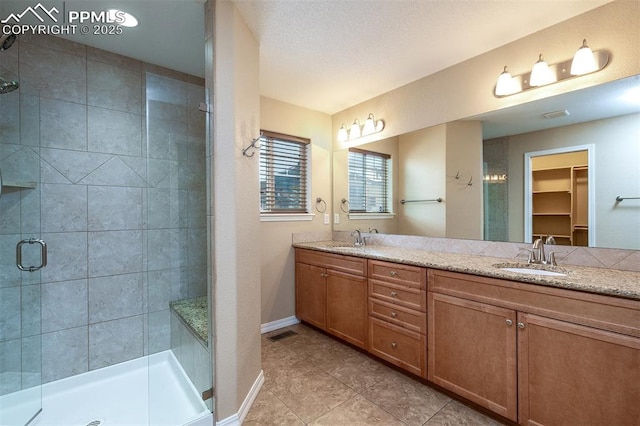 bathroom with a shower with door and vanity