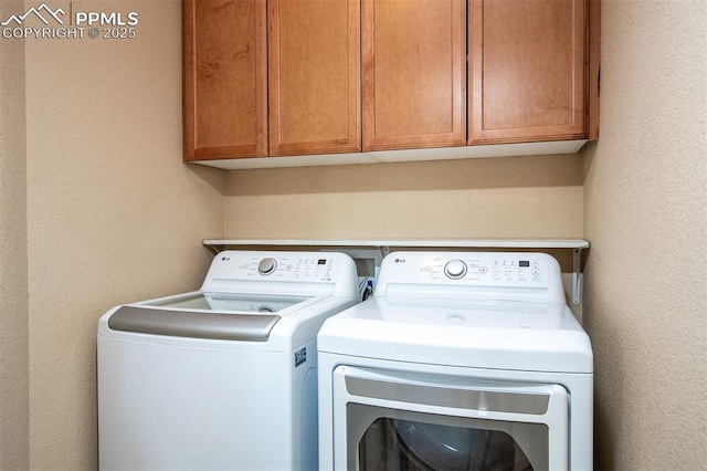 washroom with cabinets and washer and clothes dryer