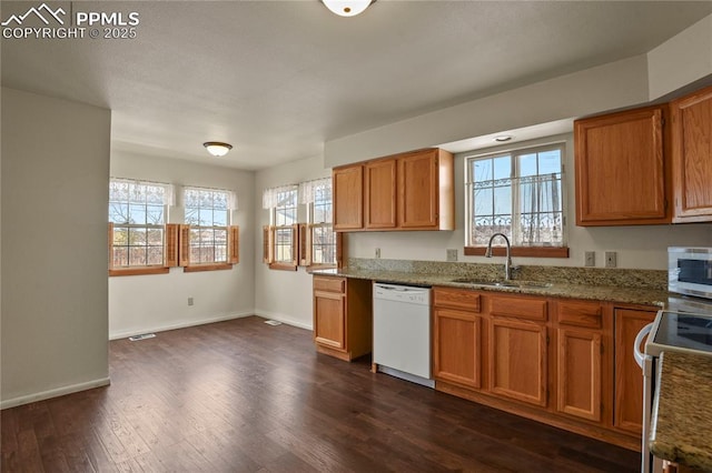 kitchen with white appliances, dark hardwood / wood-style flooring, light stone countertops, and sink