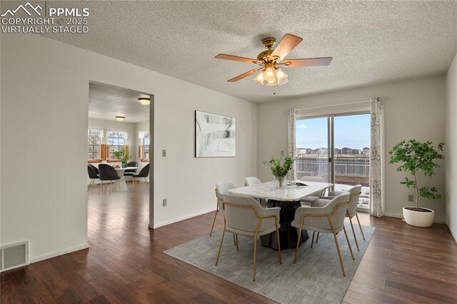 dining area with ceiling fan, dark hardwood / wood-style floors, and a textured ceiling
