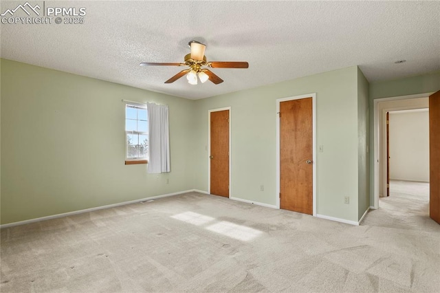 unfurnished bedroom with ceiling fan, light colored carpet, and a textured ceiling