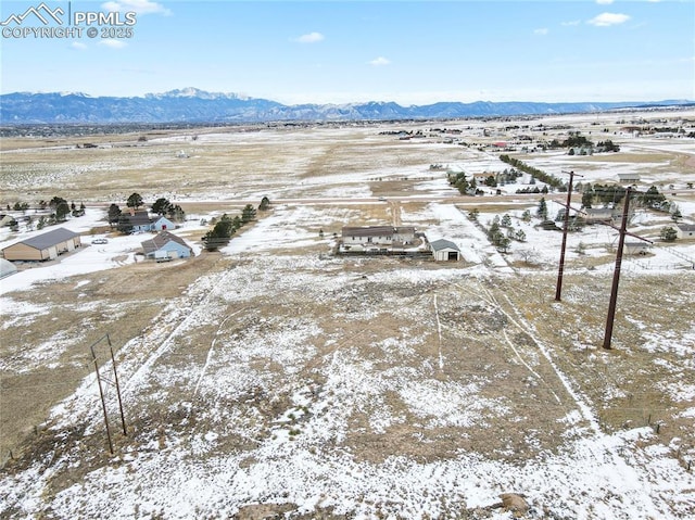 snowy aerial view featuring a mountain view