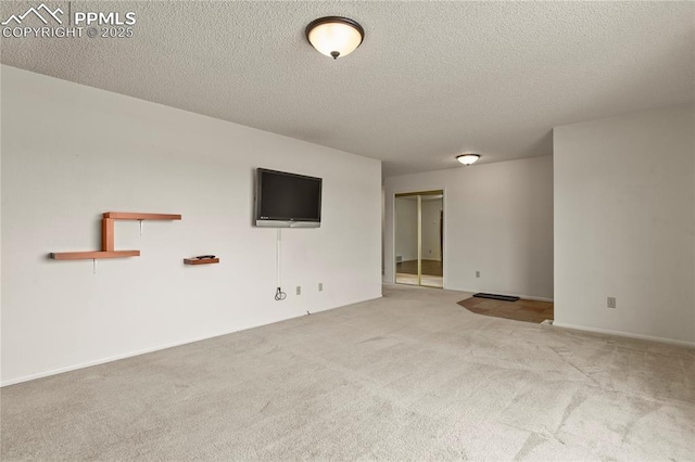 empty room with carpet flooring and a textured ceiling