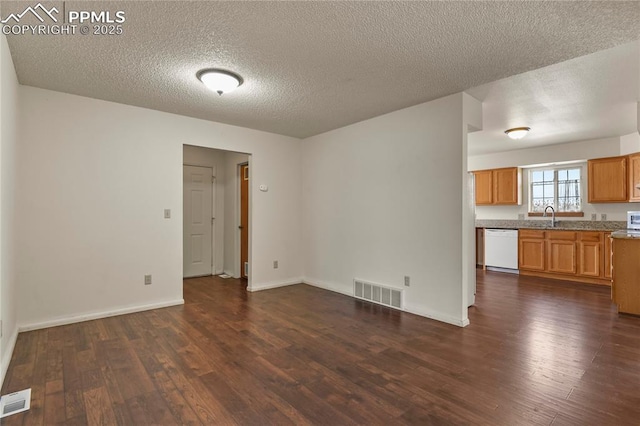 unfurnished room featuring dark wood-type flooring, sink, and a textured ceiling